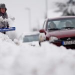 A man clears snow with a shovel as a car drive past in the western German city of Remscheid on March 6, 2010. Cold weather with snow has returned to many parts of Germany. AFP PHOTO DDP / JENS SCHLUETER GERMANY OUT (Photo credit should read JENS SCHLUETER/AFP/Getty Images)